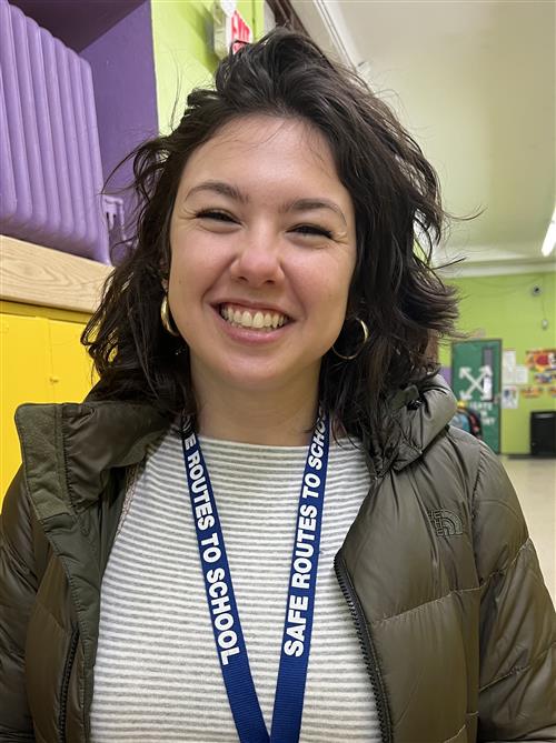 School Social Worker wearing a green jacket, blue and white blouse and smiling..